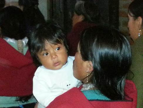 Quichua child in mother's arms Ecuador